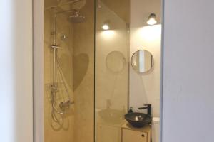 a bathroom with a shower and a glass door at Design apartments Jūrmāja in Ainaži