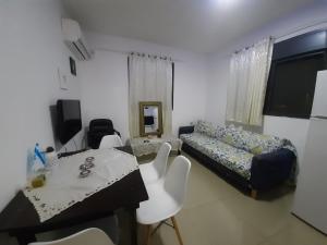 uma sala de estar com uma cama, uma mesa e cadeiras em family2 em Nahariya