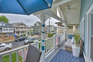 オーシャン・グローブにあるOcean Grove Apt with Balcony 1 Block to the Beach!の椅子と傘と通り付きのポーチ