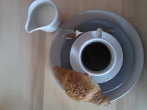 a plate with a cup of coffee and a piece of toast at Menta( Archontiko Machalioti ) in Karpenisi
