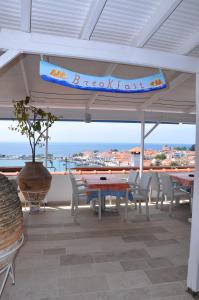 patio ze stołami i krzesłami oraz widokiem na ocean w obiekcie Remezzo Hotel & Studios w mieście Pitagorio