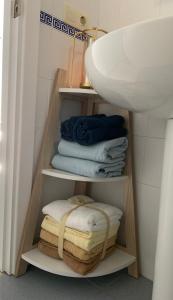 a bathroom with a sink and a pile of towels at Mirador de la ría, Isla Cristina in Isla Cristina