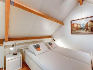 オルデンザールにあるBeautiful holiday home in Oldenzaal with bubble bathの屋根裏部屋(白いベッド付)
