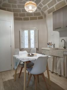 une table et des chaises dans une cuisine avec un lustre dans l'établissement casa venere 27 Favignana, à Favignana