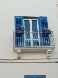 a blue window with flowers on a balcony at casa venere 27 Favignana in Favignana