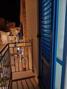 une porte donnant sur un balcon avec une table et une chaise. dans l'établissement casa venere 27 Favignana, à Favignana