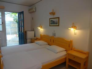 two twin beds in a room with a window at Remezzo Hotel & Studios in Pythagoreio