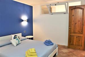 een slaapkamer met een bed met blauwe muren en een raam bij Nice and cozy apartment in Àrbatax