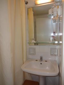 a bathroom with a sink and a mirror at Remezzo Hotel & Studios in Pythagoreio