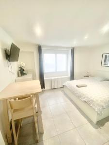 1 dormitorio con cama, escritorio y ventana en Studios meublés Brest Saint Marc, en Brest