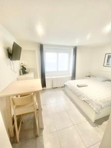 1 dormitorio con cama, escritorio y ventana en Studios meublés Brest Saint Marc, en Brest