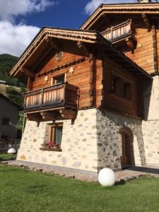 a house with a balcony on the side of it at Chrys chalet in Valfurva