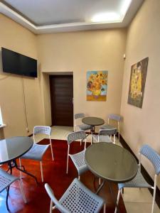 a room with tables and chairs and a flat screen tv at Ametyst Hostel in Krakow