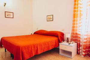 a bedroom with a bed with an orange blanket at Residence Villa la Palmas in Porto Azzurro +47 photos