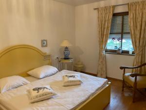 een slaapkamer met een bed met 2 kussens erop bij Szilvias Ferienwohnung in Tittling