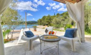 a patio with a table and chairs and a view of the water at Holiday house KIM in Kali
