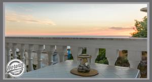 a table on a balcony with a vase on it at Dorvin Apartments in Dhërmi