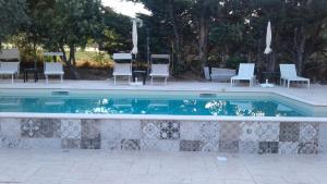 una piscina con sedie e tavolo e un gruppo di Abruzzo - Teramo tra Mare e Monti con piscina a Teramo
