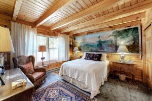 1 dormitorio con 1 cama y una gran pintura en la pared en The River Lodge en Rockwood