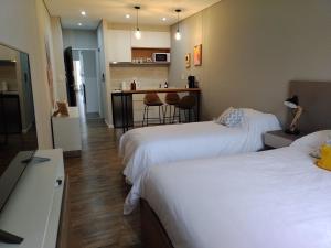a hotel room with two beds and a kitchen at LEVEL SUITES una propuesta diferente in Bahía Blanca