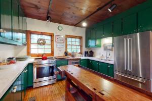 a kitchen with green cabinets and a stainless steel refrigerator at Special Serenity in Londonderry