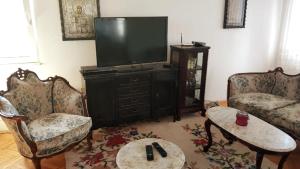 a living room with two chairs and a flat screen tv at Apartment Smakjoski Center in Ohrid
