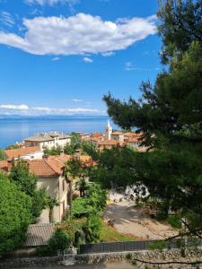 einen Blick auf eine Stadt mit dem Meer im Hintergrund in der Unterkunft Villa Jure - Apartment Mirjana in Lovran