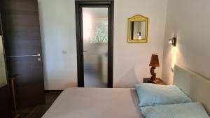 - une chambre avec un lit, un miroir et une porte dans l'établissement Terrazze al Mare (Urlaub an Sardiniens Westküste), à Torre Dei Corsari