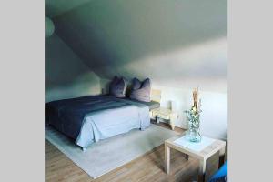 Un dormitorio con una cama con almohadas moradas y una mesa. en Ferienwohnung-/Haus mit kostenfreiem Parkplatz en Kurort Altenberg