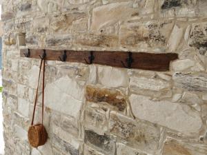 una pared de piedra con una flecha de madera. en 7Kamares en Pano Lefkara