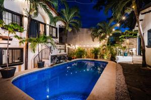 uma piscina em frente a uma casa à noite em Hotel Gardenia Tamarindo em Tamarindo