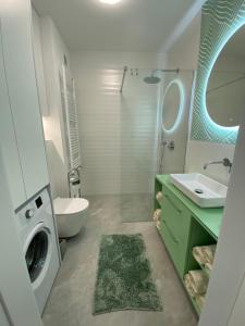 ein Badezimmer mit einem Waschbecken und einer Waschmaschine in der Unterkunft Apartament Turystyczna z widokiem na jezioro in Ostróda