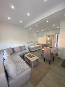 a living room with a white couch and a table at Gjoni Apartments in Ulcinj