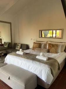 a bedroom with a large bed and a couch at SAN LAMEER ESTATE - ViLLA 1921 LUXURY STUDIO in Southbroom