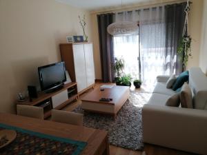 a living room with a couch and a tv at Sea & City in Leça da Palmeira