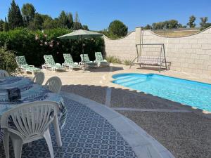 un patio con mesa y sillas junto a una piscina en Luxury Villa with private pool near Ronda, en Arriate