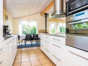 ホーフブルグにある6 person holiday home in Hovborgのキッチン(白いキャビネット、テーブル、椅子付)