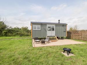 a tiny house in a yard with a table and chairs at Ridgeway in Faringdon