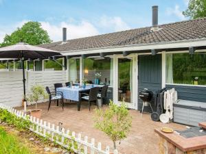 eine Terrasse mit Tisch und Stühlen und einem Sonnenschirm in der Unterkunft 4 person holiday home in Aabenraa-By Traum in Aabenraa