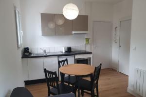 a kitchen with a table and chairs in a room at Modern Apartment Near The Sea in La Teste-de-Buch