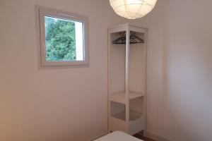 Habitación blanca con ventana y estante en Modern Apartment Near The Sea en La Teste-de-Buch