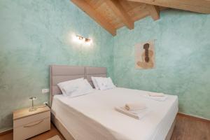 1 dormitorio con 1 cama con sábanas blancas y paredes azules en Villa Violetta Residence, en Labin 20 fotos más