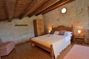 um quarto com uma cama num quarto com paredes de pedra em House Mariano em Baldaši