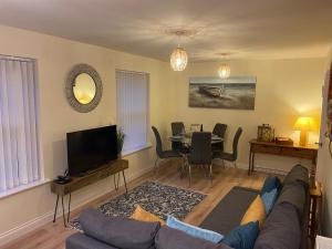 uma sala de estar com um sofá e uma mesa em Saltwater Apartment em Filey