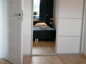 een slaapkamer met een spiegel en een bed in een kamer bij APARTAMENT GROMADZYŃ 39 in Ustrzyki Dolne