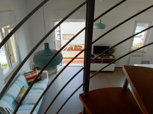 ein Zimmer mit einer Treppe mit einem Sofa und einem Tisch in der Unterkunft Big Sabaudia in Sabaudia