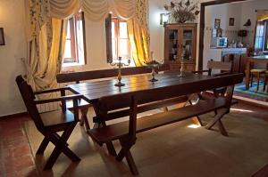 a dining room with a wooden table and two chairs at Monte Pinheiro in Rabaços