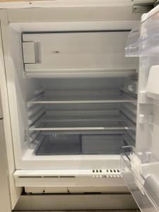 an empty refrigerator with its door open at MRTN APARTMENTS Studio & Suites - Aix-les-Bains, hypercentre in Aix-les-Bains