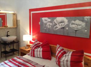 una camera da letto con una parete rossa, un lavandino e un letto di Ferienwohnungen Krakolinig a Pörtschach am Wörthersee