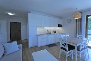 a kitchen and dining room with a table and chairs at HoliApart in Nautikka Park in Krynica Morska